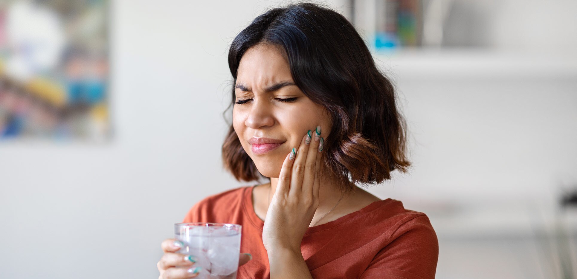 Sensitive Teeth. Young arab woman drinking water with ice and touching cheek